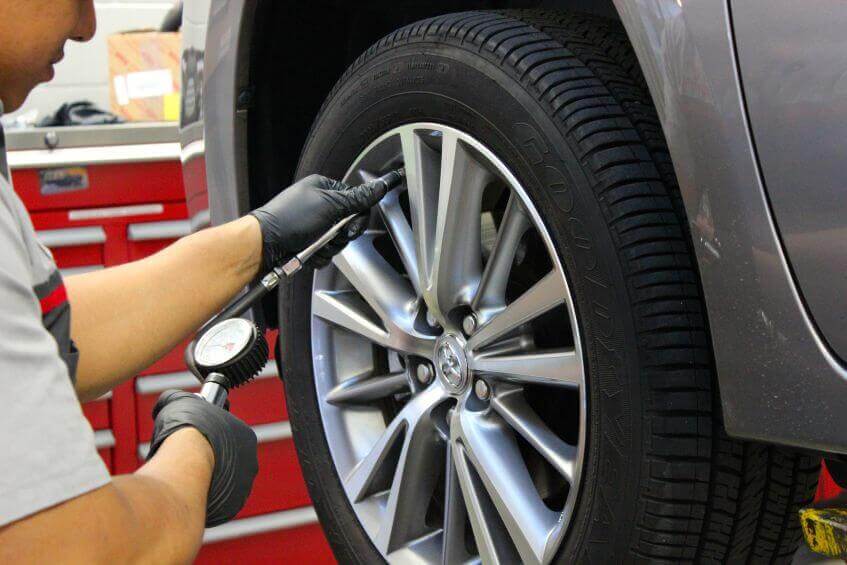 mecânico revisando pneus de um automóvel 